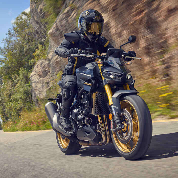 Dynamický trojštvrťový zadný záber na model CB1000 Hornet pri jazde